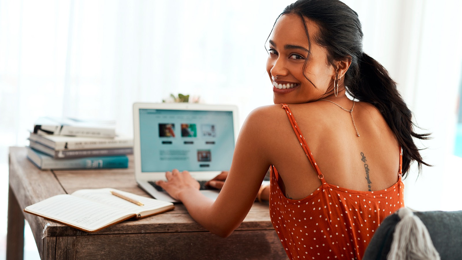 Cliente sorrindo enquanto navega no laptop em casa